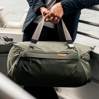 The Peak Design Duffelpack being held by a man on a boat. 