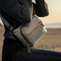 The Peak Design Everyday Sling being worn by a woman sitting.