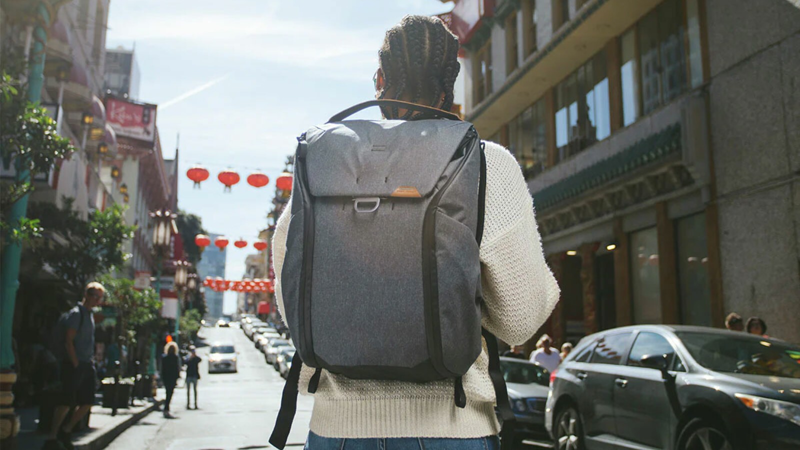 A man walking down a road wearing a Peak Design Everyday Backpack.